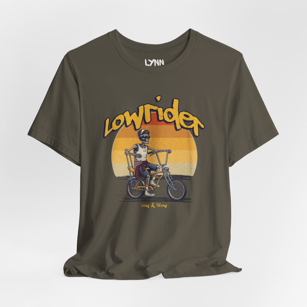 Brown t-shirt with 'Lowrider' graphic design featuring a skeleton on a bike against a sunset background.