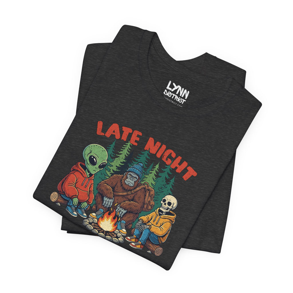 Dark gray t-shirt with 'Late Night' graphic design featuring characters around a campfire, on a white background.